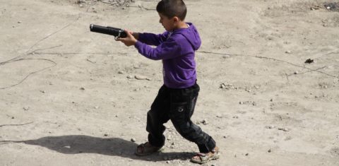 Jovem brinca com um arma de brinquedo no Afeganistão. Acabar com a banalização da violência é dos grandes desafios dos Objetivos do Desenvolvimento Sustentável (ODS) / Lauras Eye