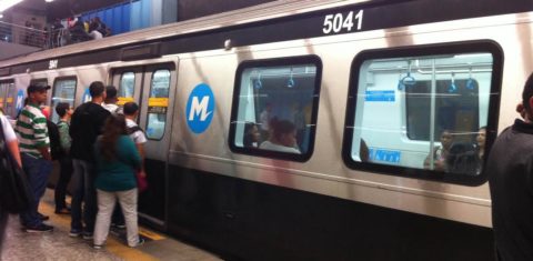 Passageiros se aglomeram na porta do metrô na esperança de conseguir um lugar sentado