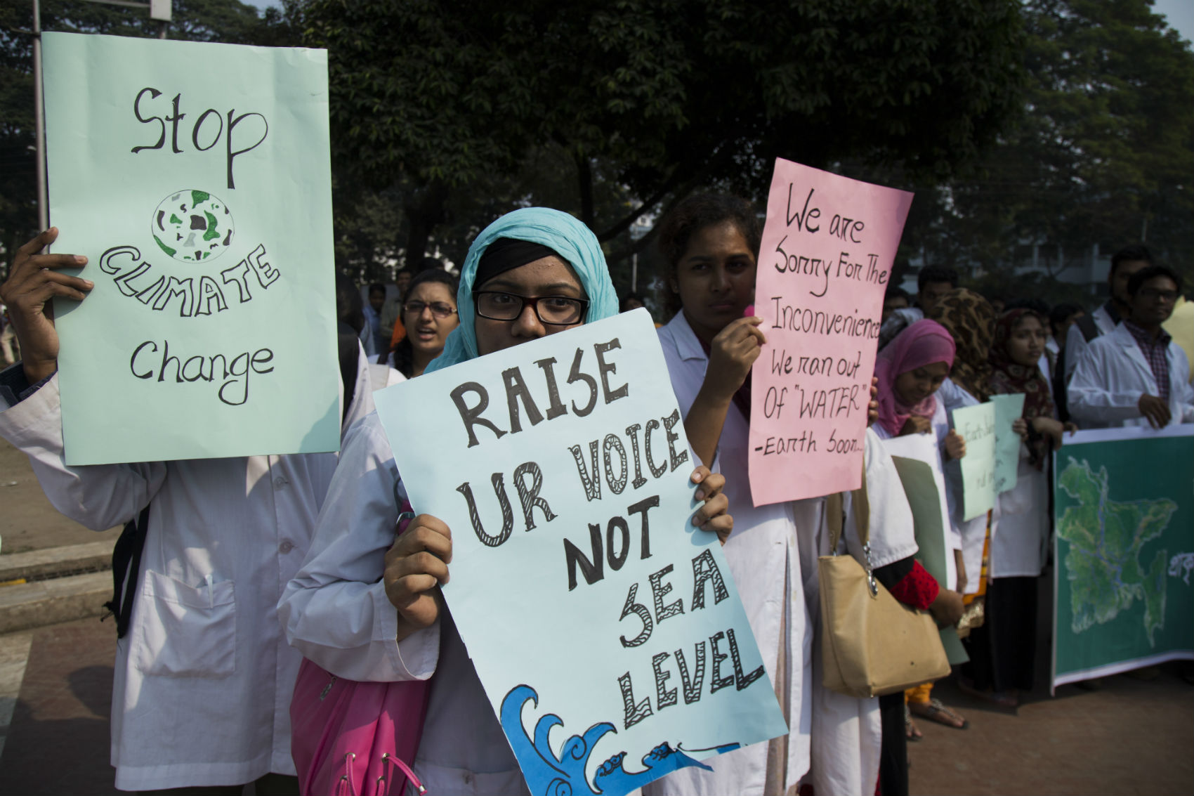 Manifestantes exibem seus cartazes na marcha de Bangladesh, país de maioria islâmica