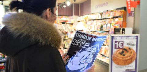 Uma mulher observa a polêmica capa da Charlie Hebdo que lembra o atentado ocorrido no ano anterior