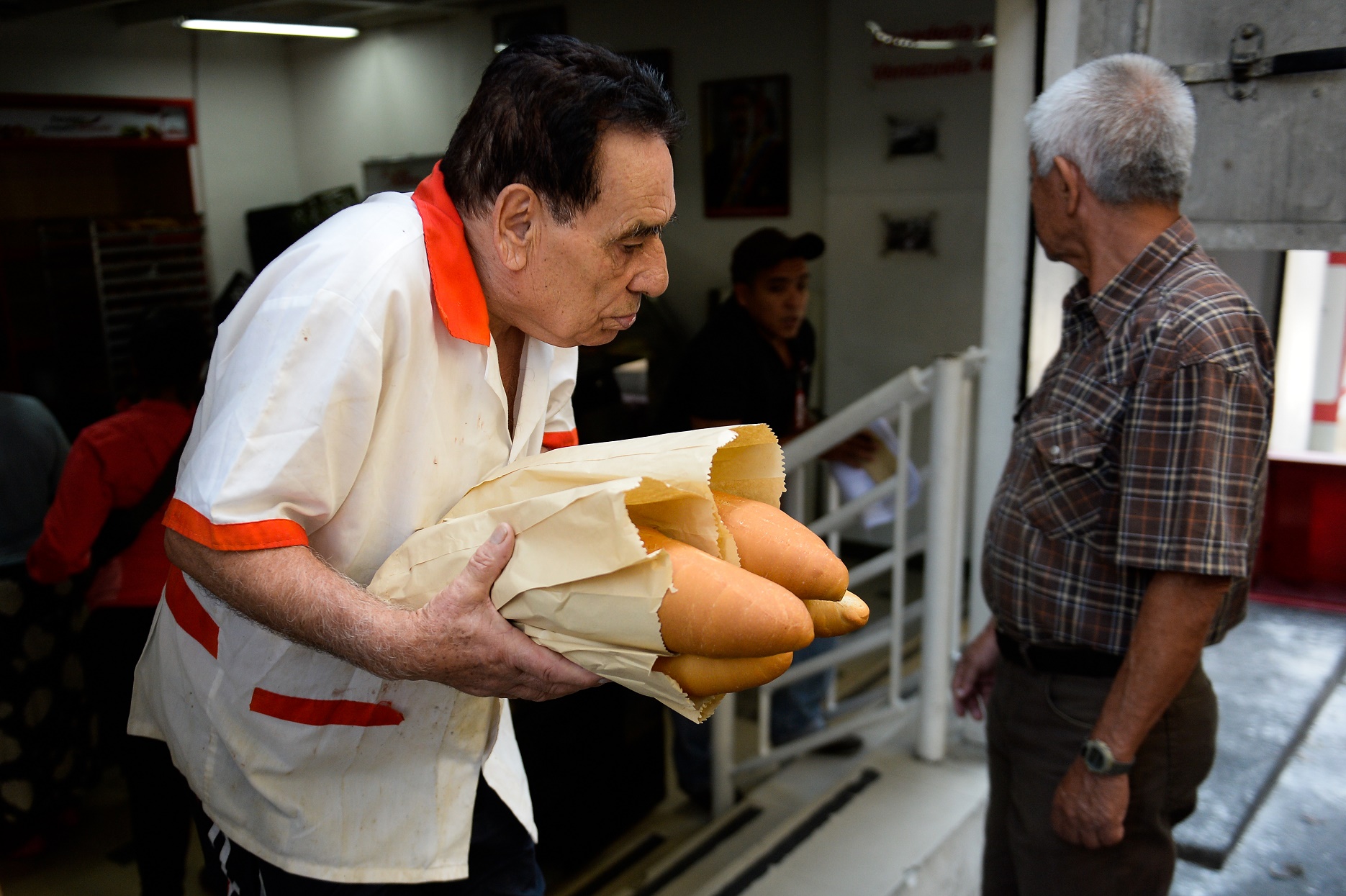 Federico Parra/AFP Venezuela: um homem consegue comprar baguetes numa das poucas padarias de Caracas que ainda vendia pão na semana passada