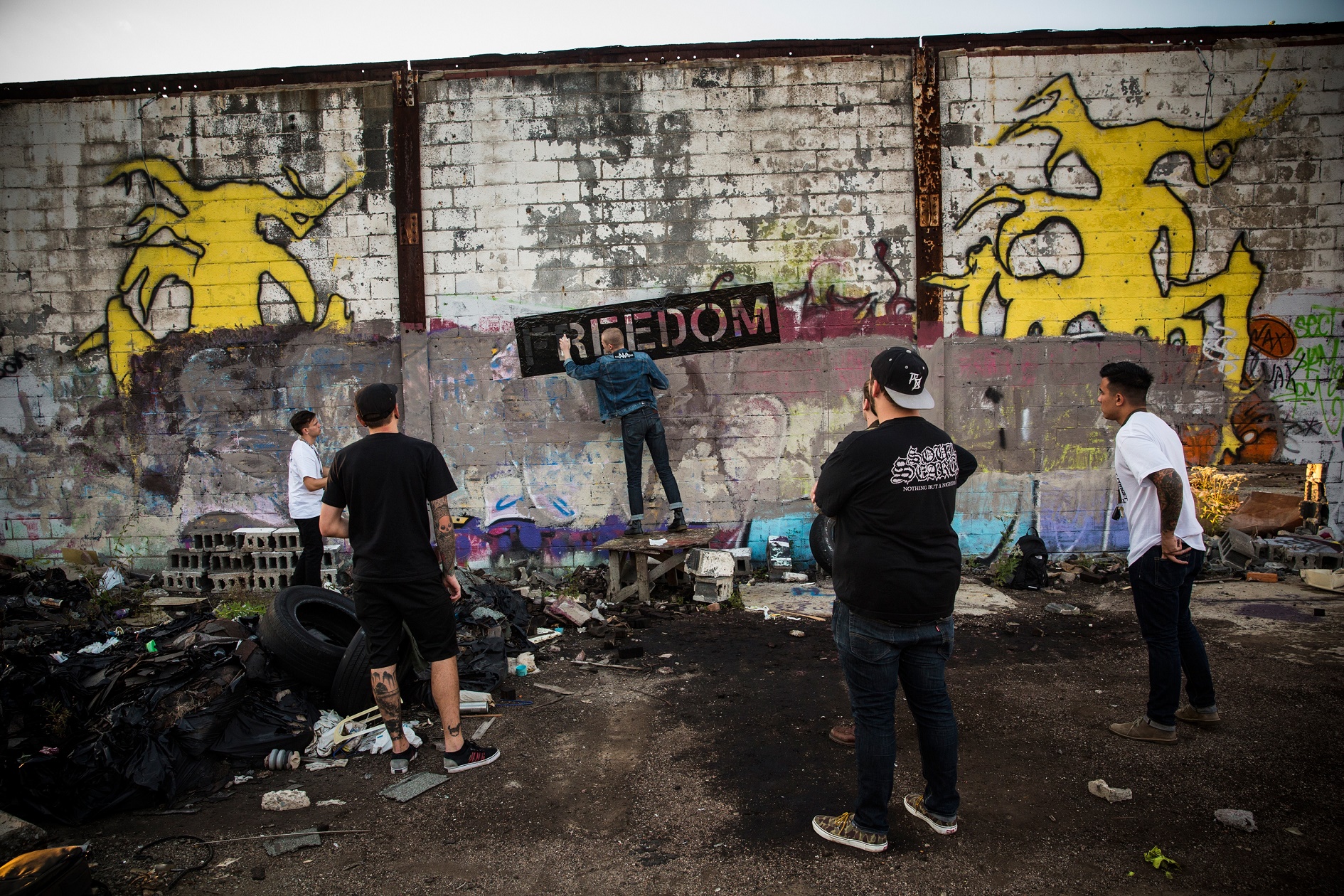 Andrew Burton / GETTY IMAGES NORTH AMERICA / AFP Os componentes da banda "Freedom" picham os muros de uma fábrica de automóveis abandonada, em Detroit, em protesto contra a crise na cidade