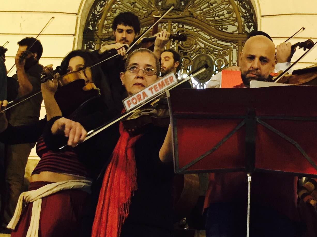 Cátia Moraes Uma violonista toca com um adesivo de ‘Fora Temer’ grudado no arco de seu instrumento e chama a atenção dos fotógrafos