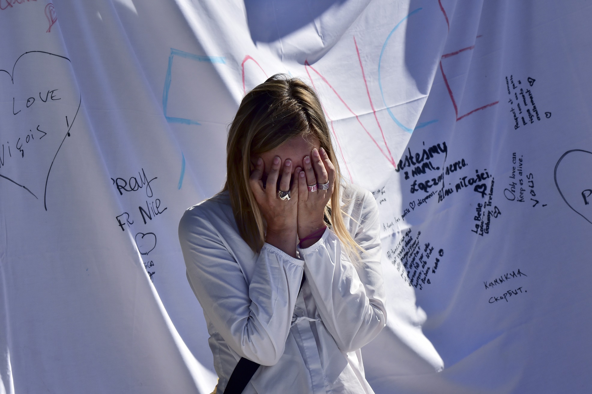 GIUSEPPE CACACE / AFP Uma mulher chora em frente ao memorial pelas vítimas do atentado que matou 84 pessoas esta semana, em NIce, no sul da França