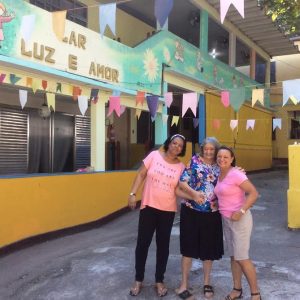 Foto de Wilson Aquino Vó Nescy (no meio) e duas voluntárias do projeto
