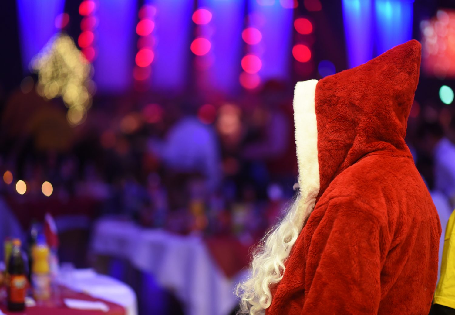 A man dressed as Santa Claus greets guests during a traditional Christmas party for homeless people and others in need at Estrel Hotel in Berlin, Germany, 21 December 2015. Warm clothes, small gifts and a show programme are offered to the guests in addition to roast goose and beer. The event has been held by German singer Frank Zander, the Diakonisches Werk, a charitable organization of Protestant churches, and Estrel Hotel for 20 years. 3000 people attended the party this year. Photo: JENS KALAENE/dpa