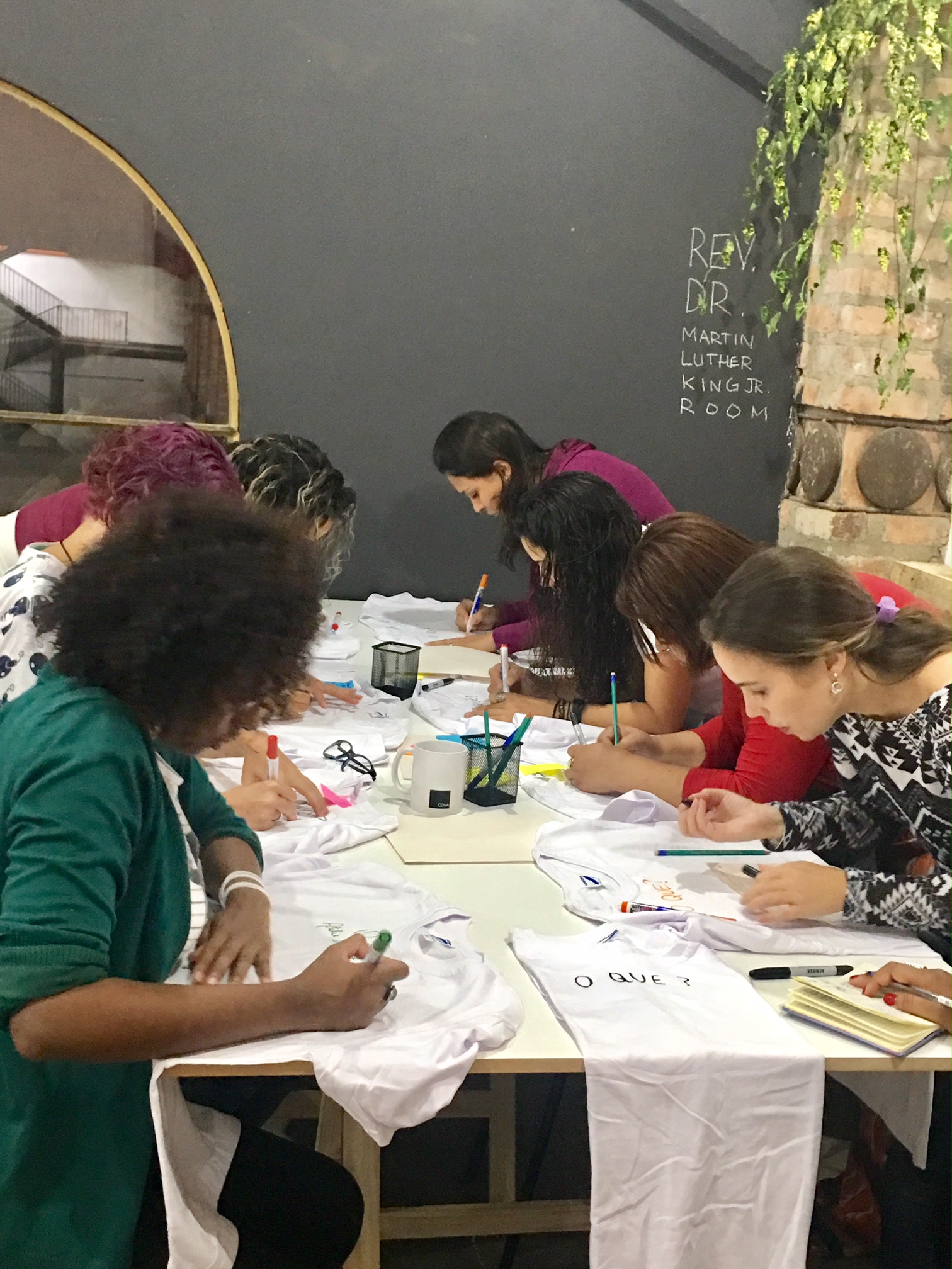 Na aula, alunos escrevem valores de seus negócios em uma camiseta