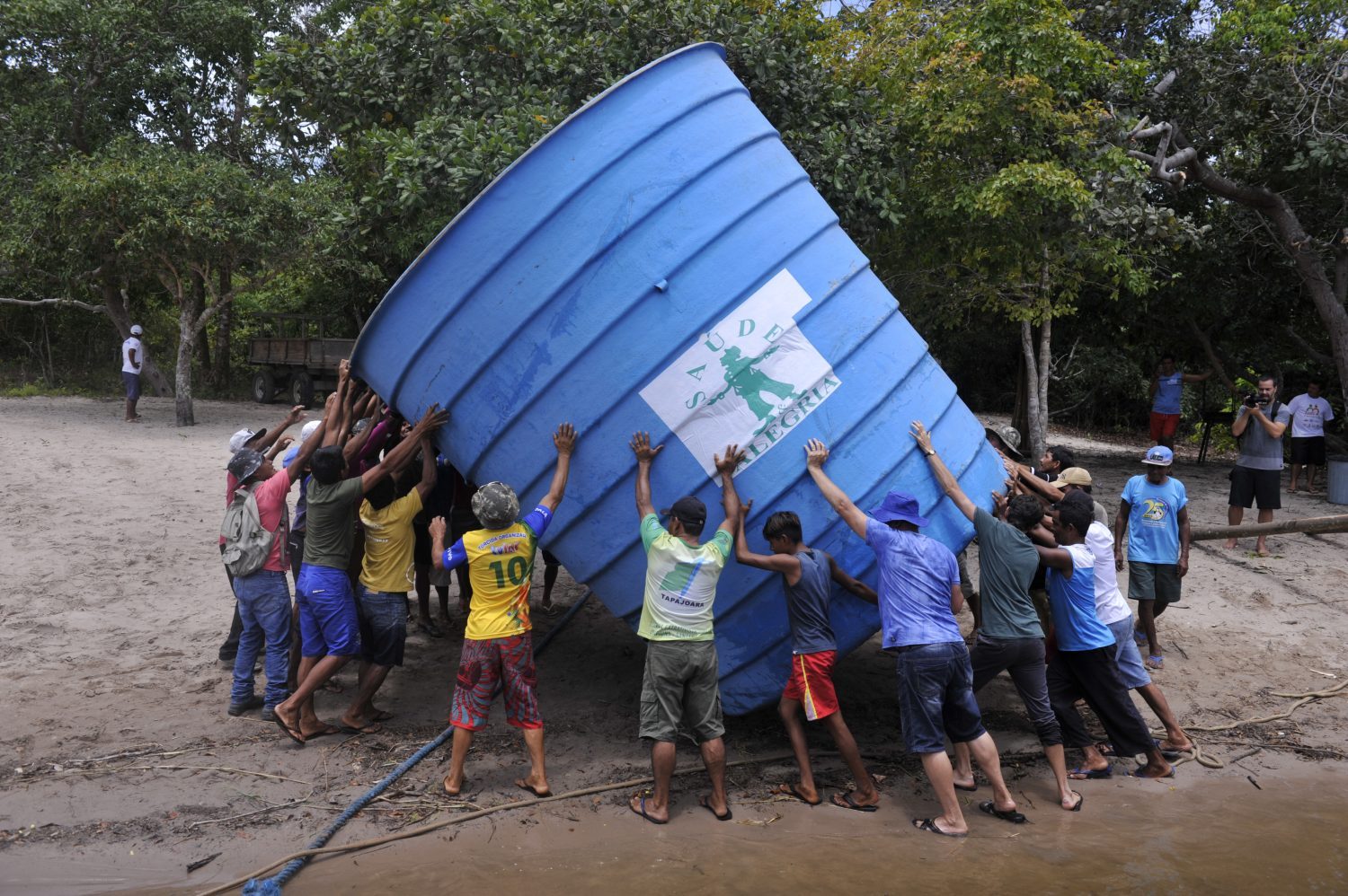 Foto Chico Ferreira/Divulgação Ribeirinhos da comunidade de Anumã, no Tapajós, carregam caixa d'agua comunitária (Foto Chico Ferreira/Divulgação)