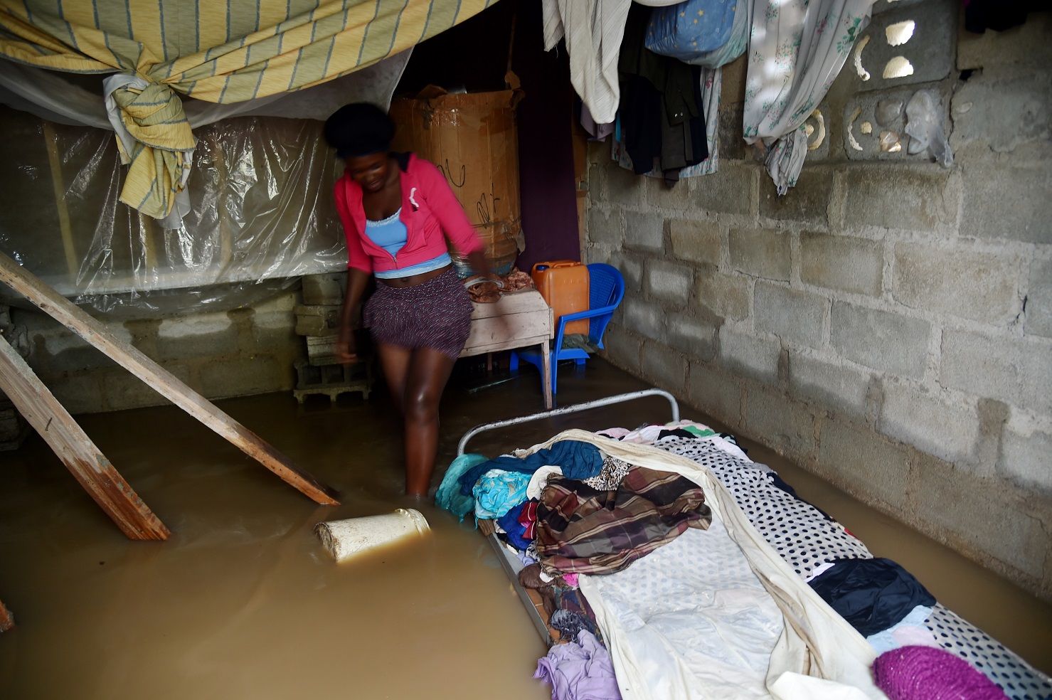 Foto Hector Retamal/AFP Marie Charlotte caminha dentro da sua casa, no Haiti, inundada pelo furacão Irma. Foto Hector Retamal/AFP