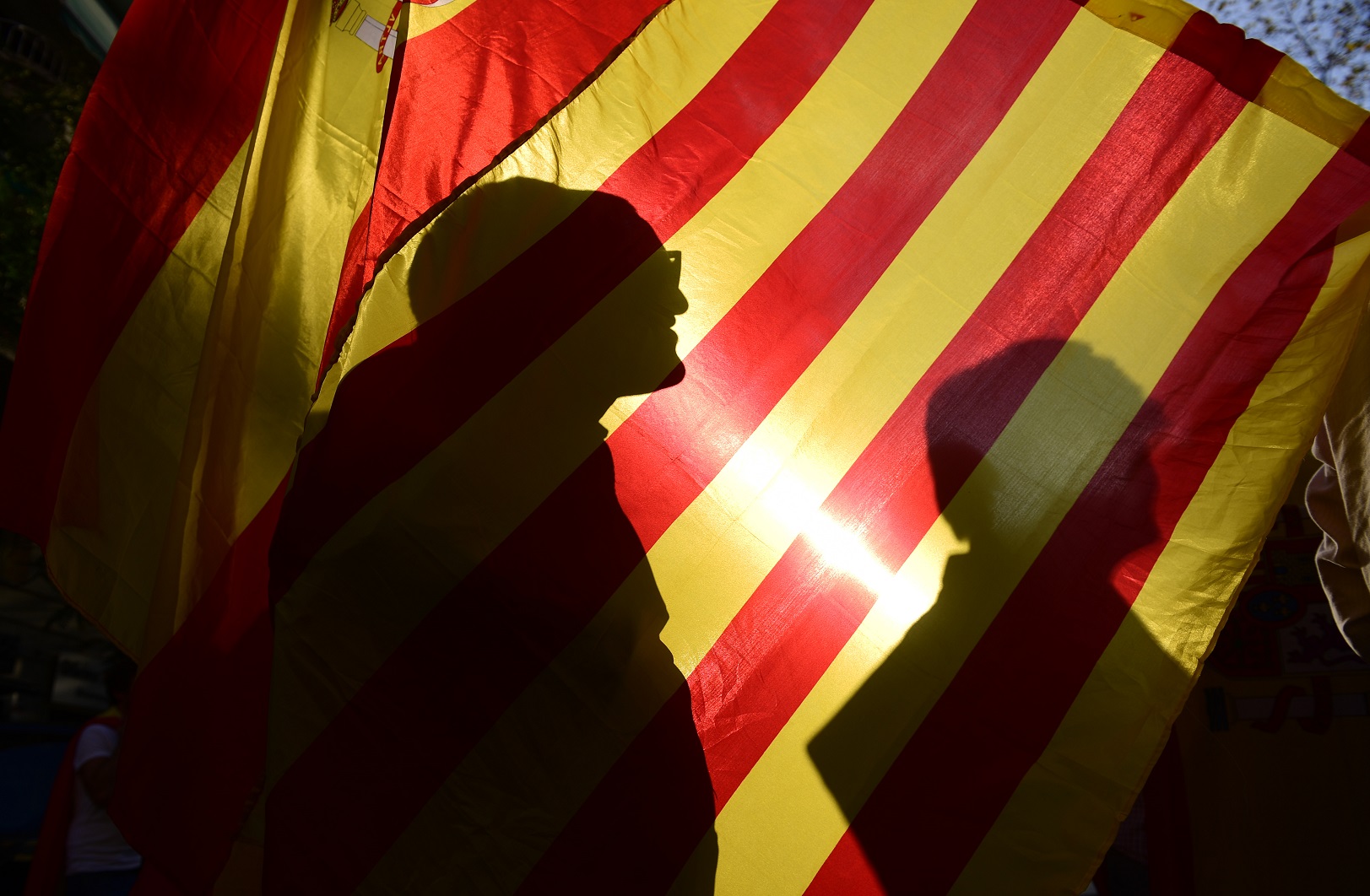 A sombra dos manifestantes na bandeira da conturbada Catalunha. Foto Pierre-Philippe Marcou/AFP