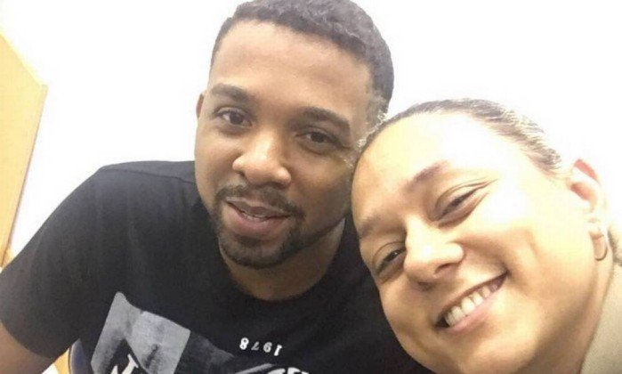 O inexplicável sorriso que une a policial e o bandido. Foto Reprodução