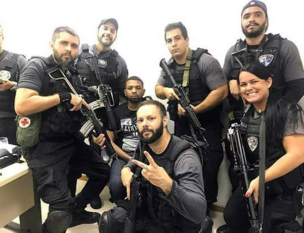 Policiais fazem selfie com o traficante Rogério 157, ao fundo. Foto Reprodução