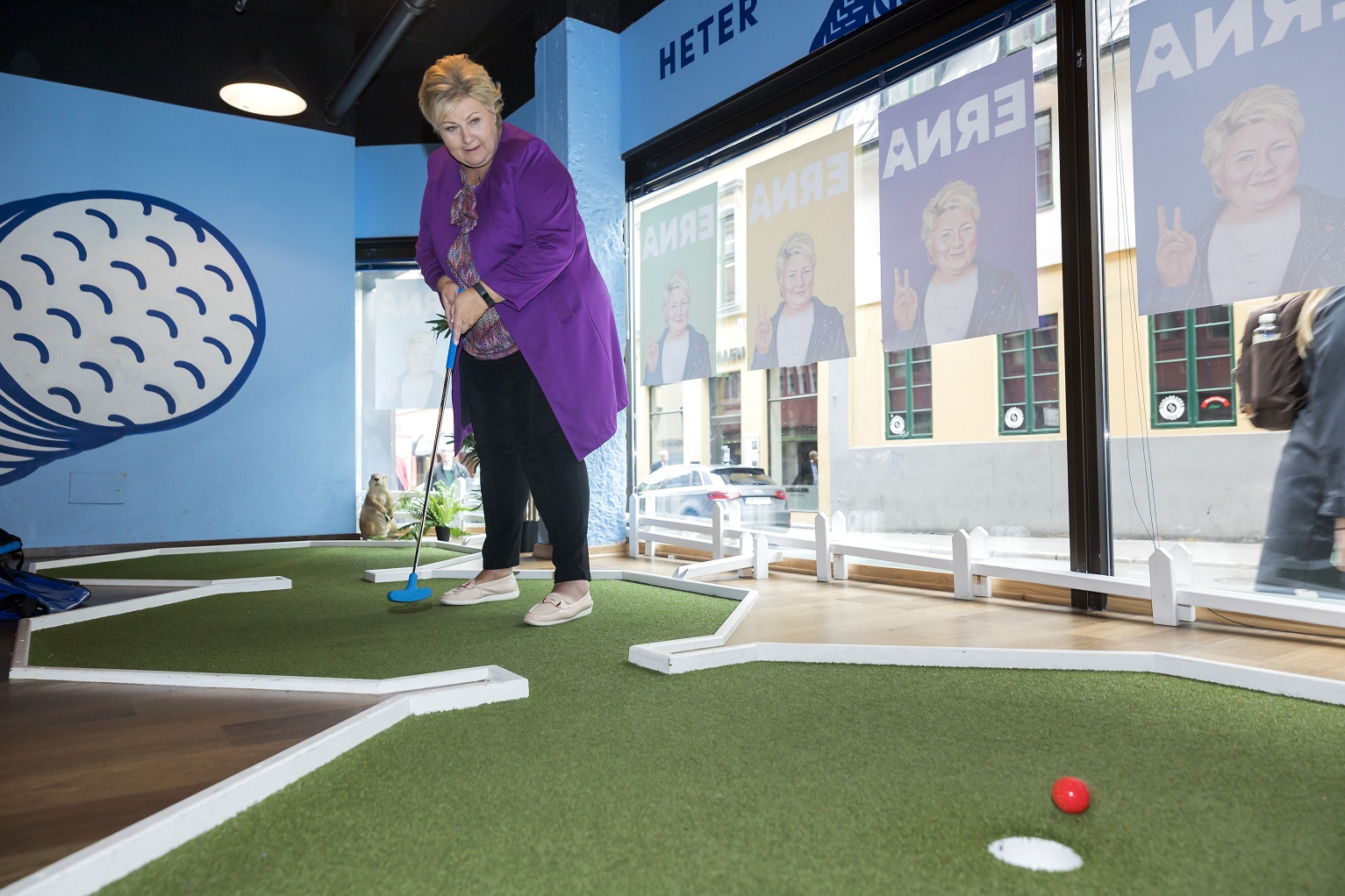 Foto Cornelius Poppe / NTB A primeira-ministra da Noruega, Erna Solberg , tenta acertar o buraco numa partida de minigolfe em Oslo. Foto Cornelius Poppe / NTB