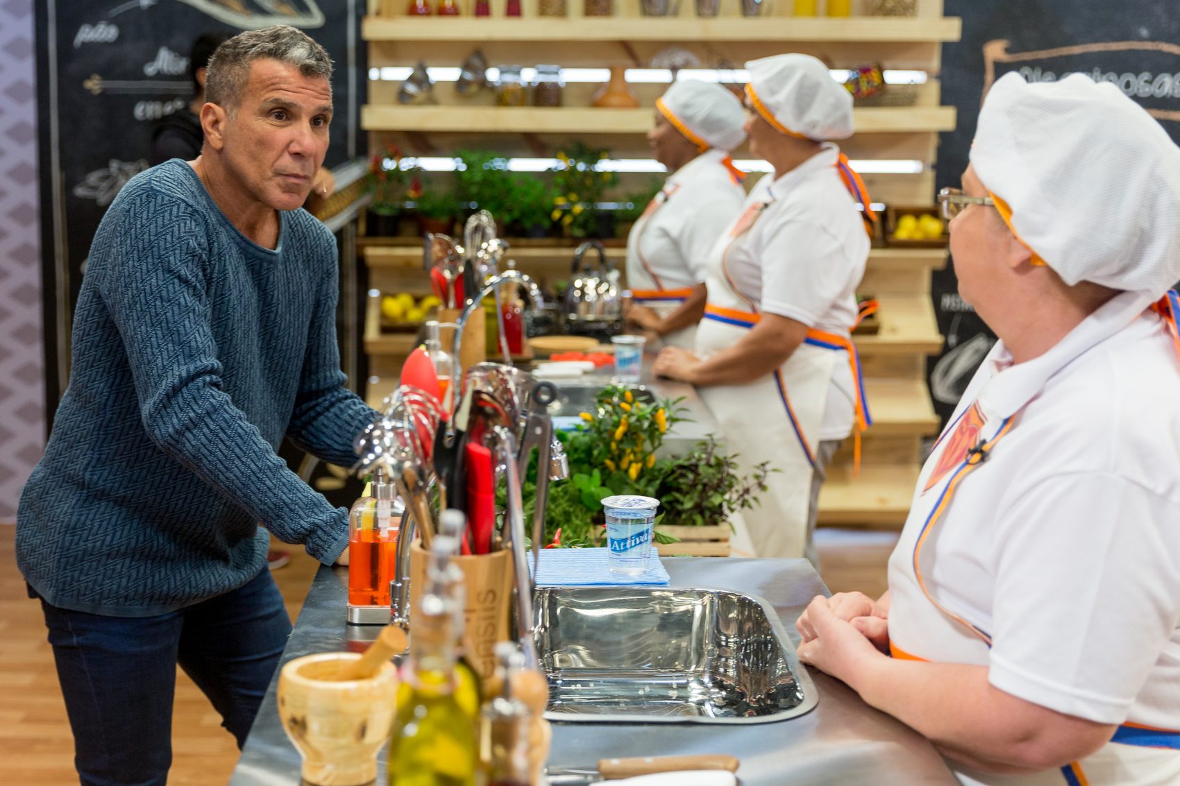 O apresentador e as merendeiras na bancada, ao estilo "Masterchef" (Foto Carlos Henrique Santos/divulgação TV Escola)