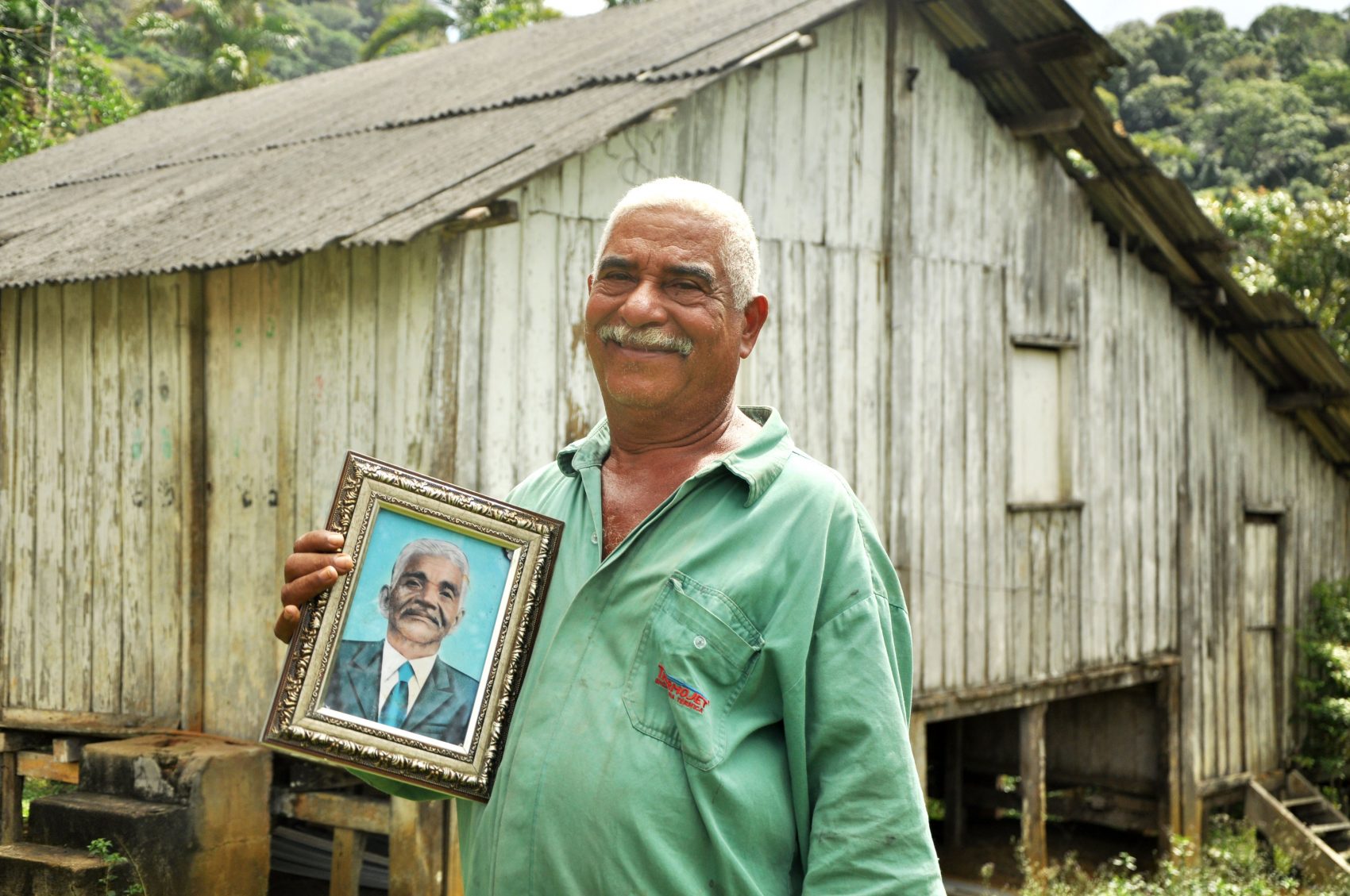 Seu Lírio (Rosemiro Ferreira da Silva), pajé da Serra do Padeiro, com o retrato de seu pai, João de Nô (Foto: Daniela Alarcon/divulgação)