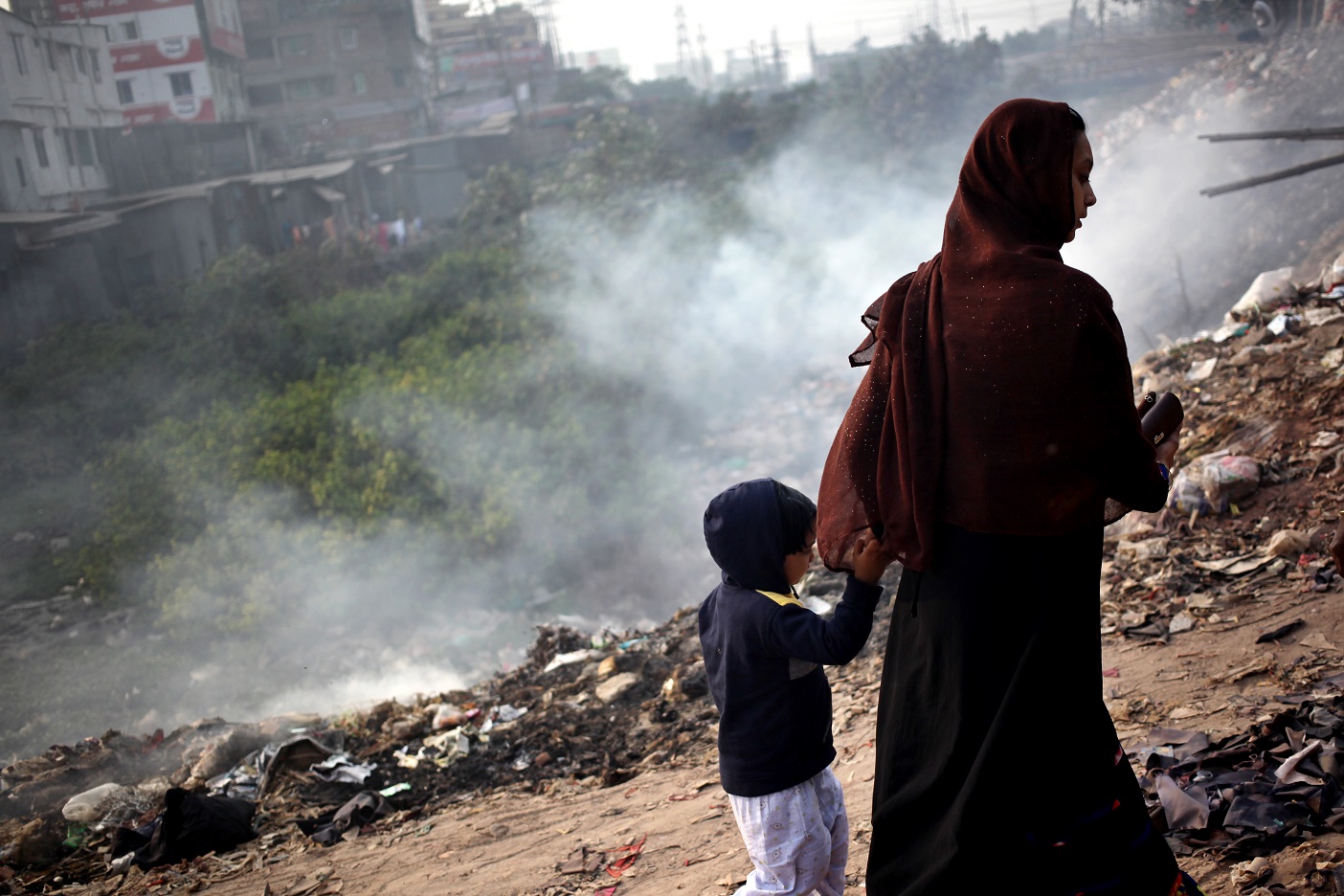Foto Syed Mahamudur Rahman/NurPhoto Mulher carrega o filho pelas margens do poluído rio Buriganga, em Bangladesh. Foto Syed Mahamudur Rahman/NurPhoto