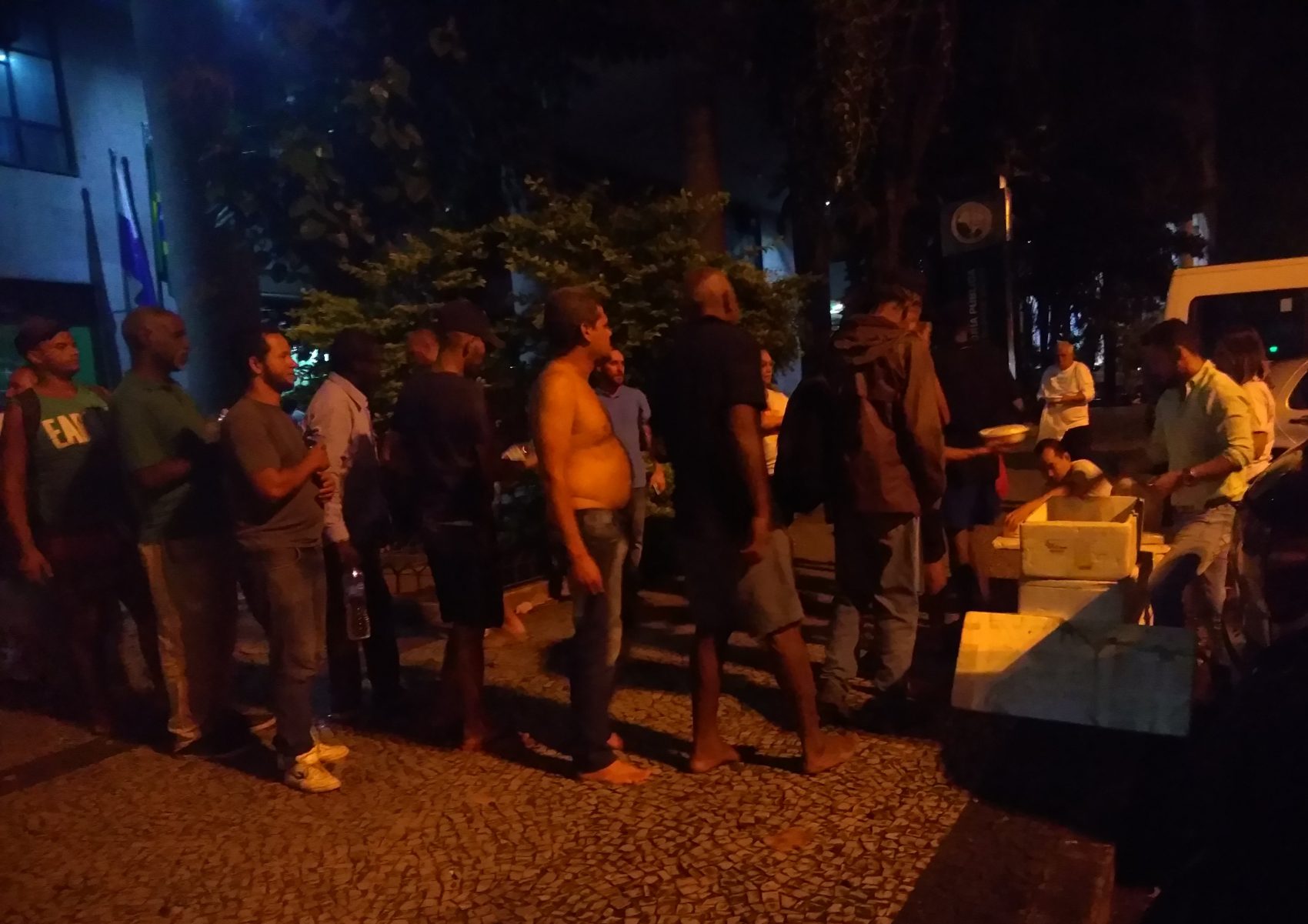 (Foto de Bárbara Lopes) Moradores de rua fazem fila para receber quentinhas, além de sobremesa e suco: voluntários atendem mais de 100 pessoas a cada duas semanas (Foto de Bárbara Lopes)