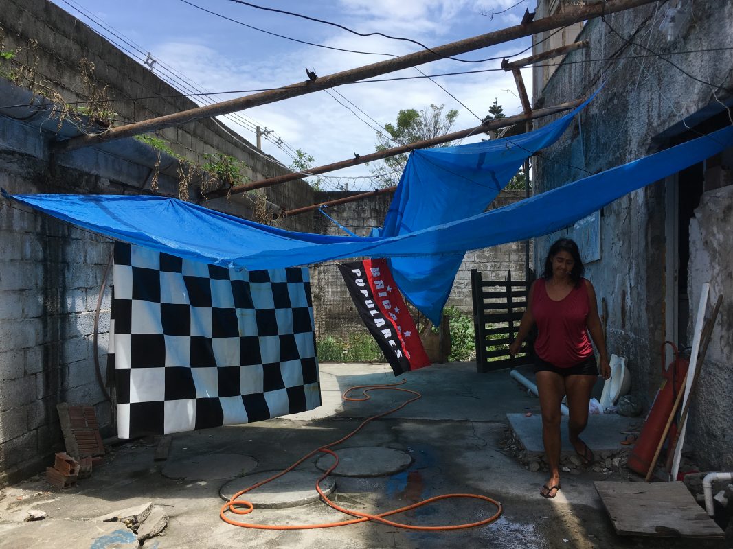 Andrea caminha pela ocupação: monitoramento de invasões, cuidado na convivência dos vizinhos e olho no feijão que vai queimar. Foto de Maria Carolina Rodrigues