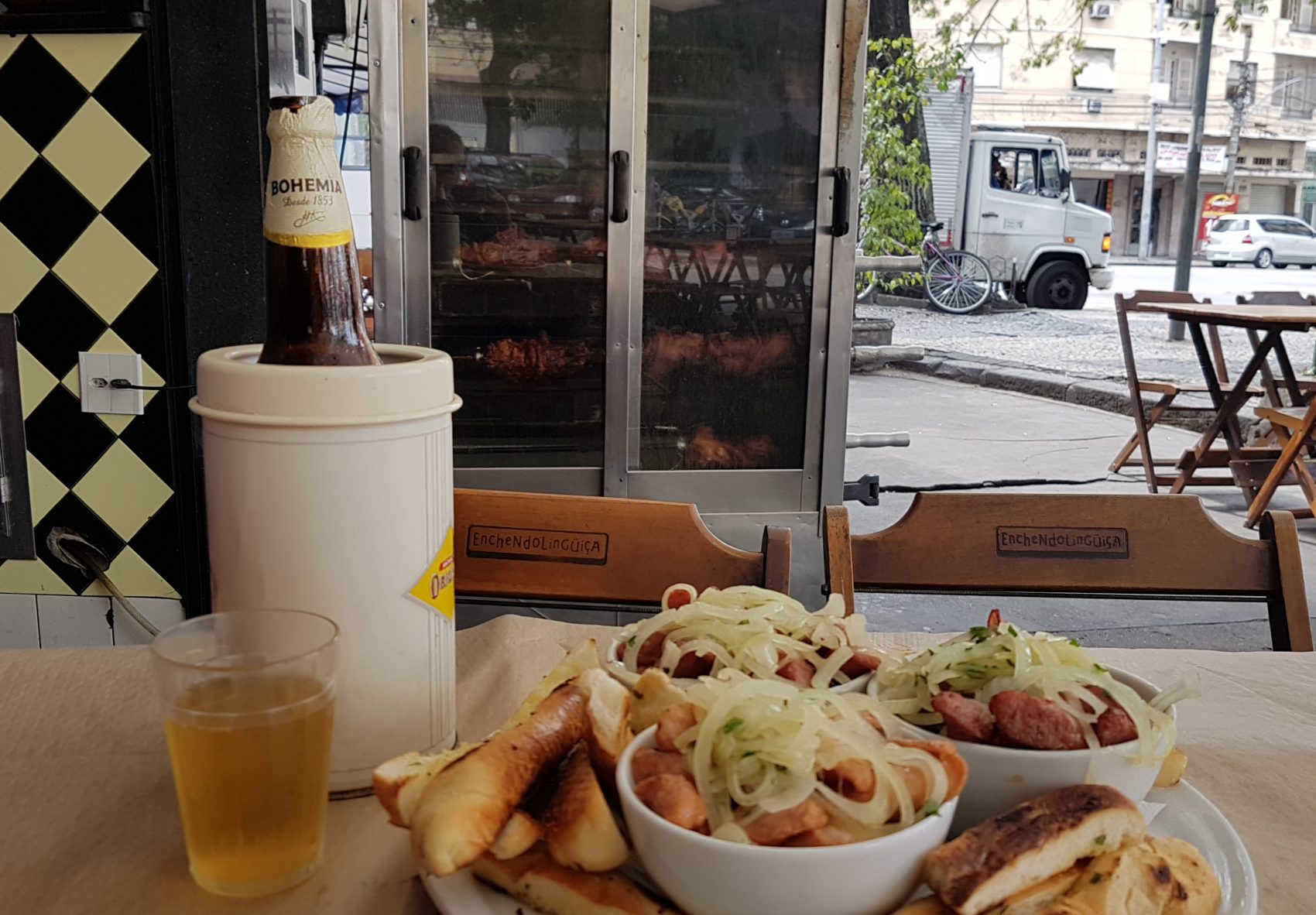 Três tipos de linguiça, cerveja e a vista joelho de porco girando na assadeira: atrações do bar Enchendo Linguiça, no Grajaú (Foto: Oscar Valporto)