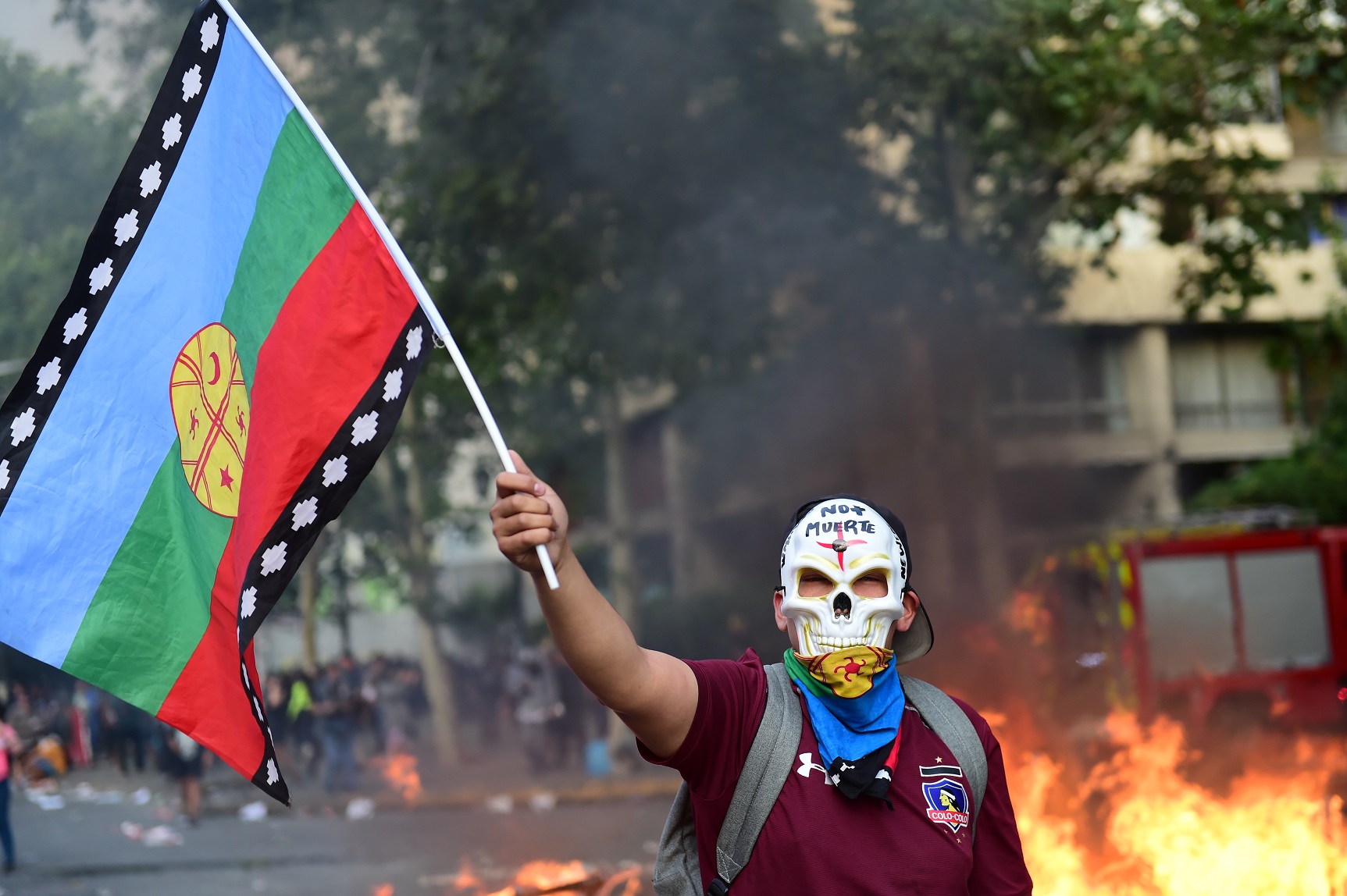 Foto Martin Bernetti/AFP Manifestante, com uma bandeira do povo indígena Mapuche, protesta contra a política econômica do governo chileno. Foto Martin Bernetti/AFP