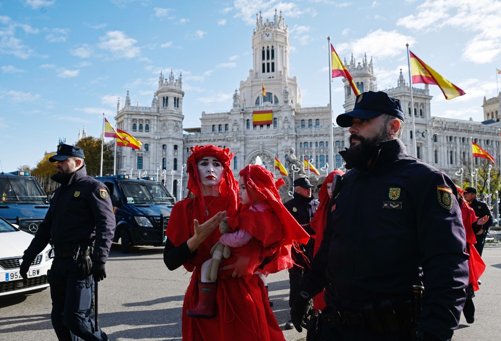 Foto de Oscar Del Pozo/ AFP Police officers walk beside global environmental movement Extinction Rebellion activists during a protest at the Cibeles square in Madrid, on December 3, 2019. - Spain's Socialist government offered to host this year's UN climate conference, known as COP25, from December 2 to December 13, 2019, after the event's original host Chile withdrew last month due to deadly riots over economic inequality. (Photo by OSCAR DEL POZO / AFP)