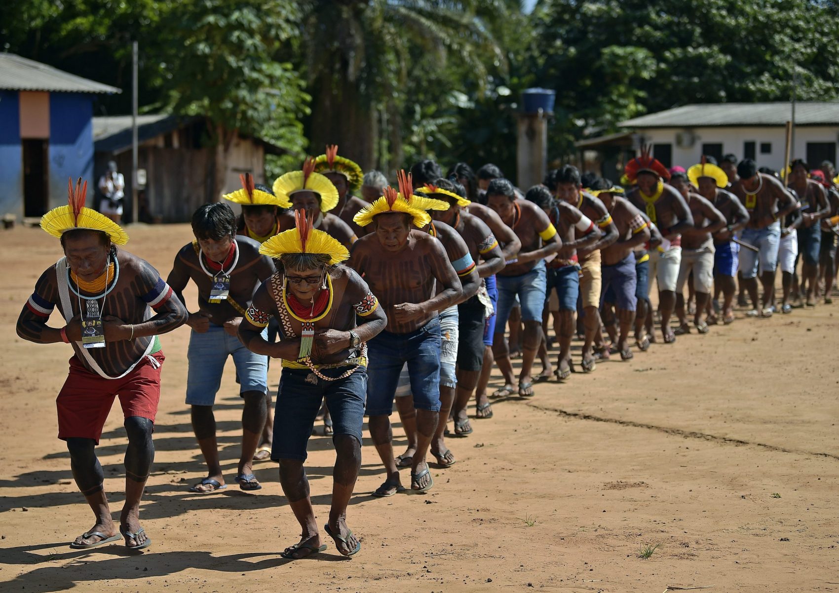Indígenas dançam em homenagem a Raoni, na Capoto Jarina, terra indígena cortada por uma estrada por onde trafegam carretas de soja e gado: floresta afetada pelo desmatamento dos dois lados da via (Foto: Carl de Souza/AFP)
