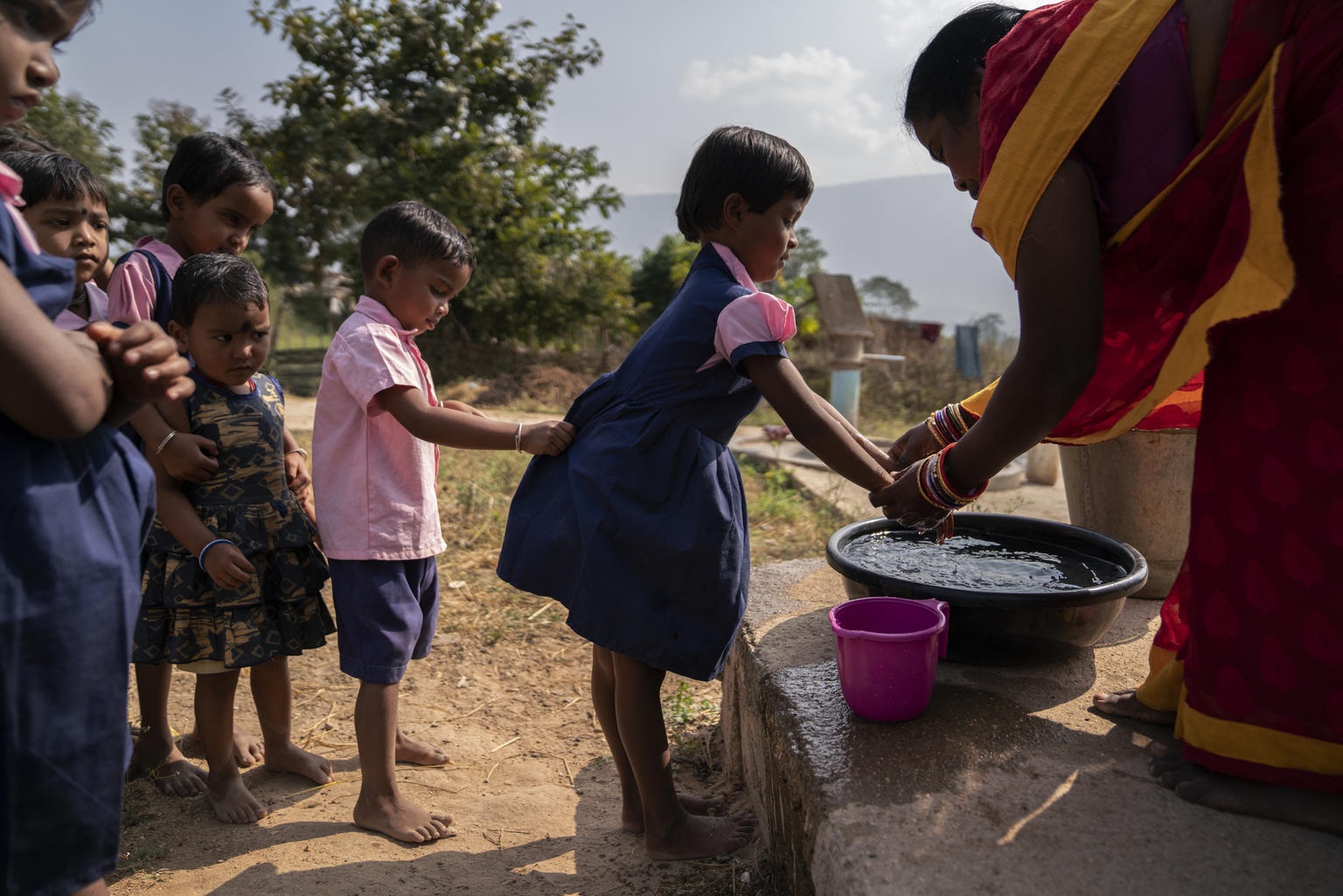 Crianças fazem fila para lavar as mãos do lado de fora de uma escola na Índia. Foto Unicef
