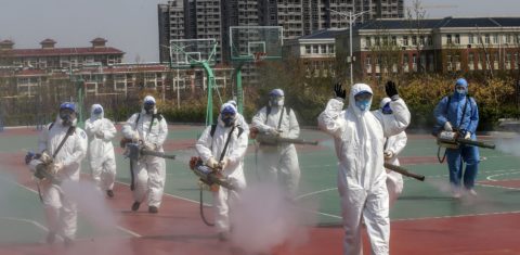 Voluntários desinfetam as quadras esportivas das escolas que se preparam para reabrir na província de Shandong, na China. Foto STR/AFP/China Out