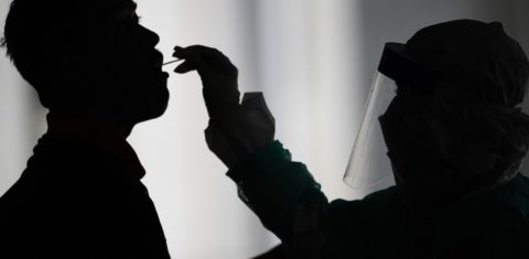 Profissional de saúde usa um swab para coletar uma amostra para o teste de coronavírus de um homem em Gombak, nos arredores de Kuala Lumpur, na Malásia. Foto Mohd Rasfan / AFP)