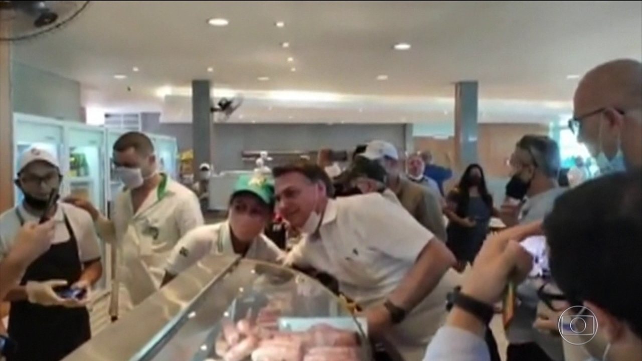Bolsonaro. com a máscara no queixo, posa com admiradores em passeio em Goiás: Capitão Corona em campanha contra o isolamento social (Foto: Reprodução)