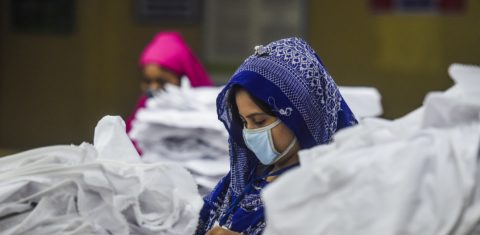Mulheres usando máscaras trabalham em uma fábrica de roupas durante o bloqueio imposto pelo governo de Bangladesh como medida preventiva contra a propagação da covid-19. Foto Munir Uz Zaman/AFP