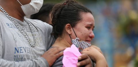 Valcione Soares e Vitor Soares choram a morte de sua avó Enedina Soares, de 71 anos, vítima de covid-19, durante seu enterro no cemitério de Nossa Senhora da Piedade, em Manaus. Foto Michael Dantas/AFP
