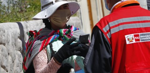 Uma mulher é entrevistada por funcionários do Ministério da Mulher e das Populações Vulneráveis ​​enquanto ocupa um lugar na fila fora de uma instituição Administradora de Fundos de Pensão na cidade andina de Puno, perto da fronteira com a Bolívia. Foto Carlos Mamani/AFP