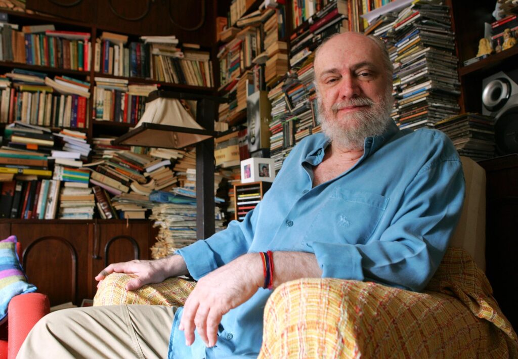 Aldir Blanc em sua biblioteca de onde quase não saía: mais de 600 letras de música e 12 livros (Foto: Divulgação)