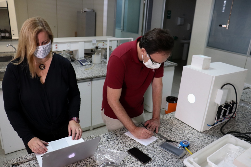 Os professores Suellen Lattes e Joatan Rodrigues no laboratório da UFS: tecnologia, com uso de radiação, permite a reutilização do equipamento de proteção individual no enfrentamento à covid-19 (Foto: Josafá Neto)