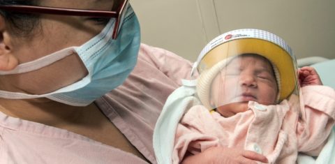 Uma mulher usando máscara facial posa com seu bebê recém-nascido - usando um escudo facial - na unidade de Neonatologia do Hospital México em San Jose, na Costa Rica. Foto Ezequiel Becerra/AFP