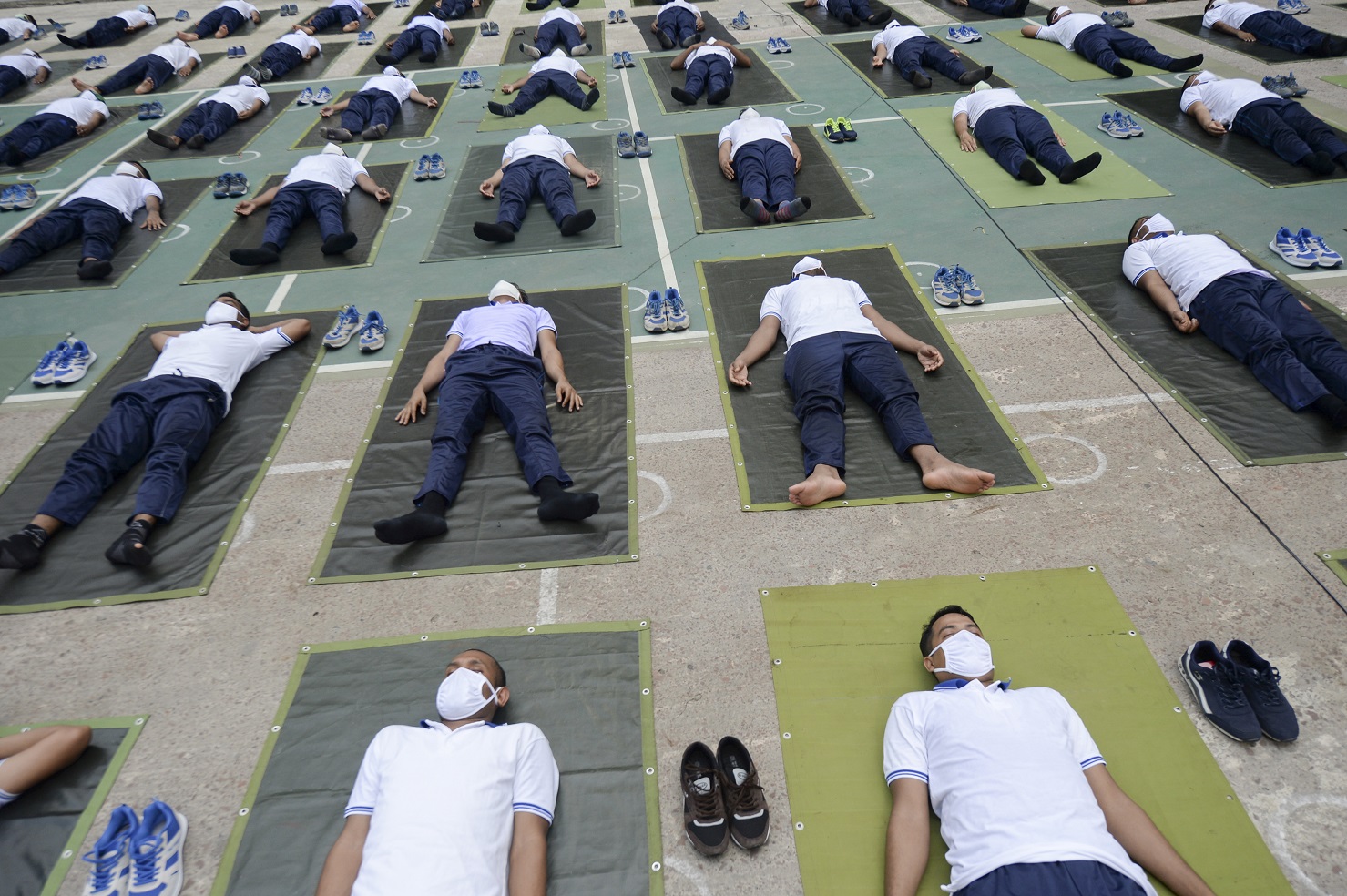 Membros da polícia de Daca, em Bangladesh, participam de uma sessão de ioga para melhorar o sistema imunológico durante a pandemia de coronavírus. Foto Munir Uz Zaman/AFP