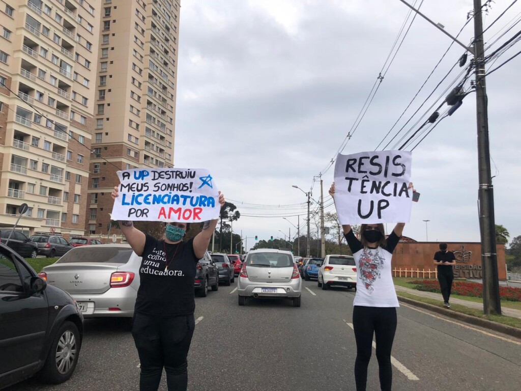 Manifestantes com cartazes contra a direção da UP: demissões por e-mail e vídeoconferência (Foto: Resiste UP)