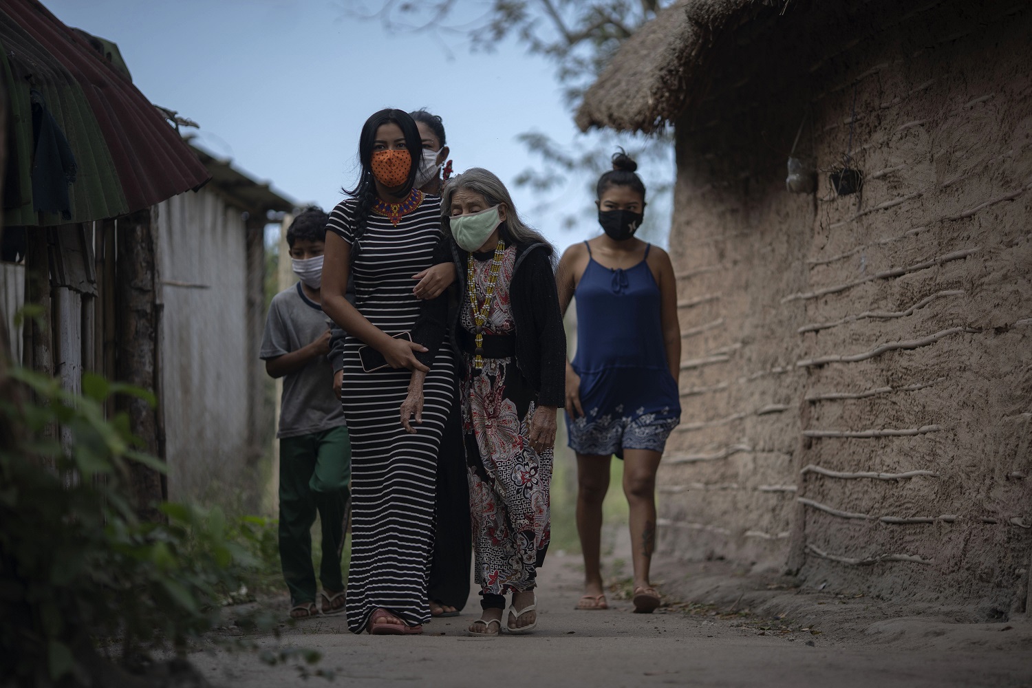 Uma indígena guarani idosa é acompanhada a um posto de saúde para um teste da covid-19 no campo da tribo São Mata Verde Bonita, em Maricá, no Rio de Janeiro. Foto Mauro Pimentel/AFP
