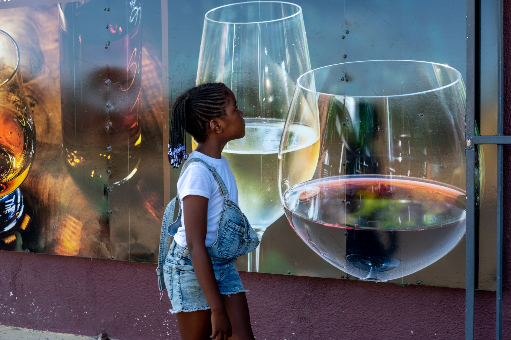 Menina passa por propaganda de bebida alcoólica: crianças viram alvo de campanhas de marketing para incentivar consumo de produtos nada saudáveis (Foto: OMS)