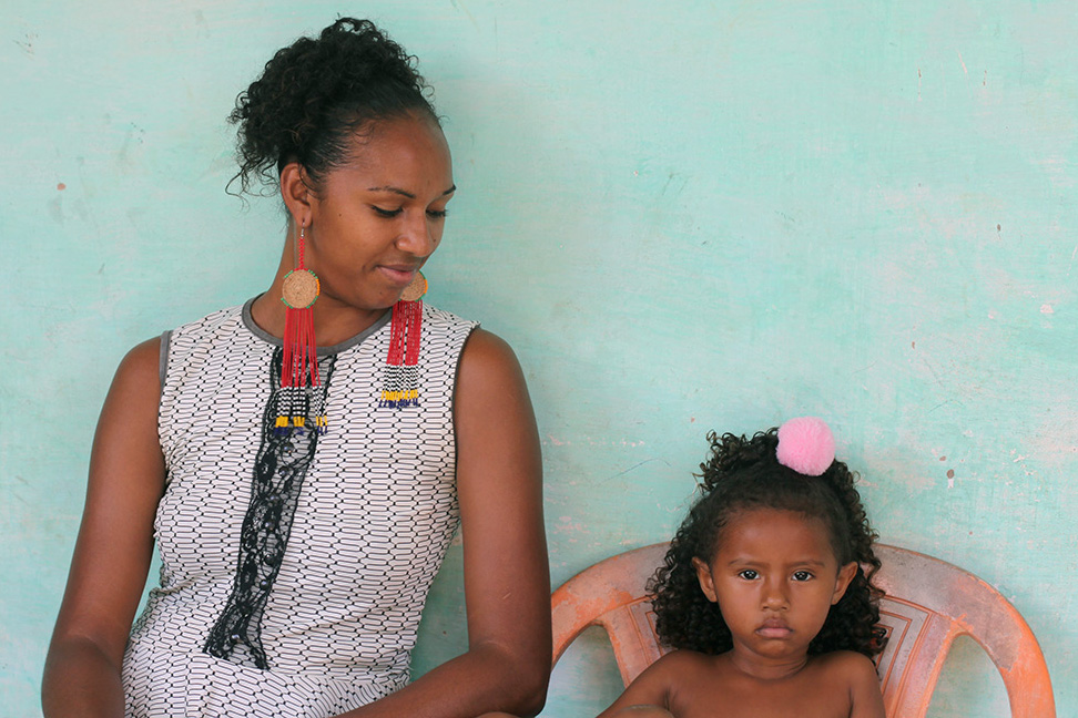Ana Tássia com a pequena Allana: quando sai para trabalhar, mãe deixa menina com a avó, que planta hortaliças na roça da comunidade (Foto: Djuena Tikuna)