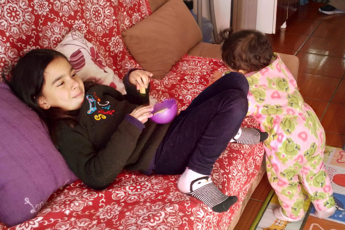 Laura (com a irmã bebê) assistindo televisão: sem aulas presenciais, menina de 5 anos passa o dia em frente a telas e está com pouco apetite (Emilene Lopes)