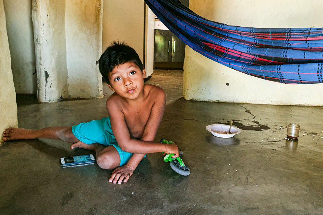Henrique, de 5 anos, brinca com o celular em casa: rotina escolar interrompida e lições impressas (Foto: Felipe Azevedo/Lição de Casa)