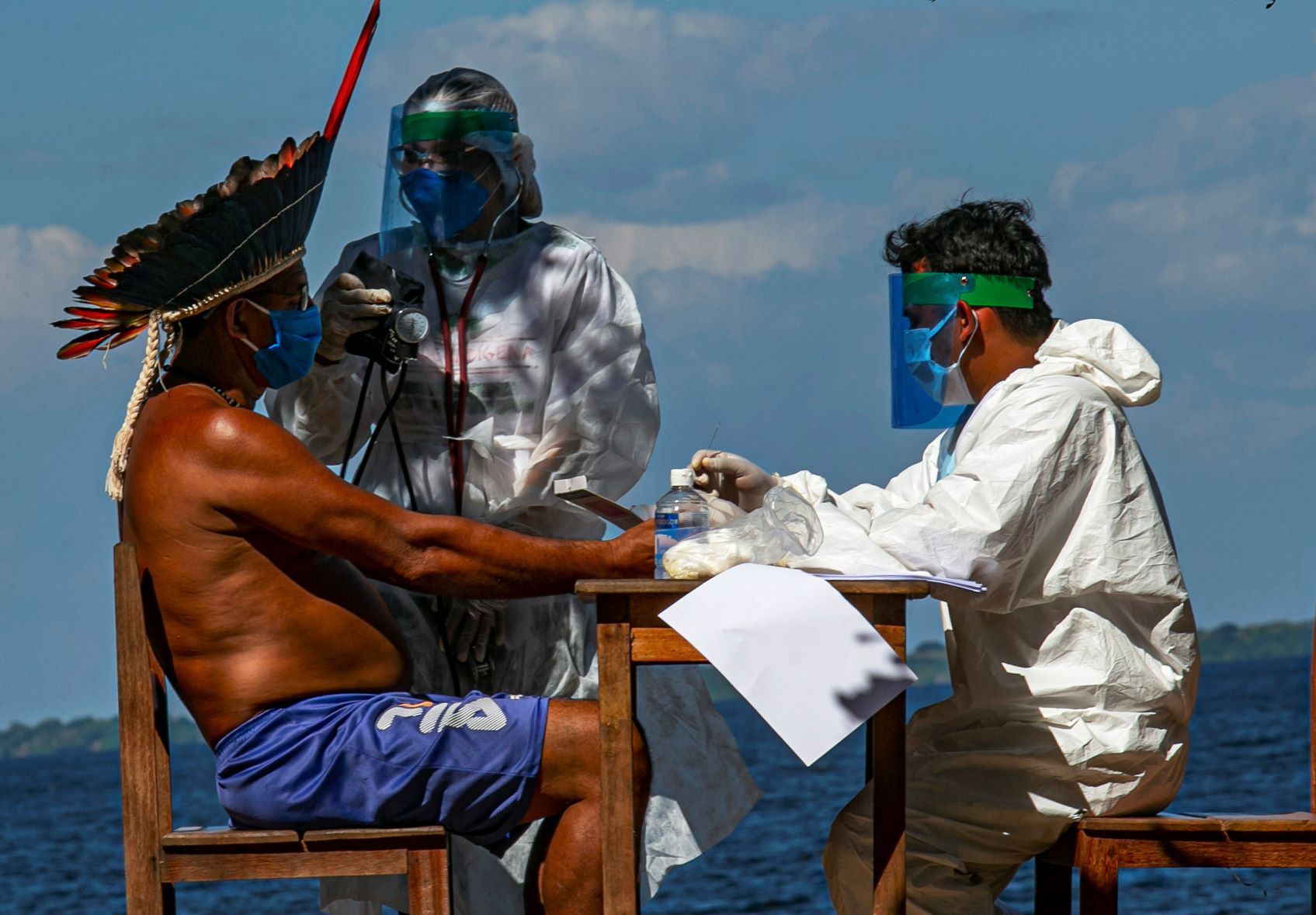Enfermeiros indígenas da Sesai testam o cacique Domingos, da etnia Arapium, em aldeia às margens do Rio Tapajós, perto de Santarém, no Pará: Amazônia brasileira tem mais de 12 mil indígenas com covid-19 (Foto: Tarso Sarraf/AFP)