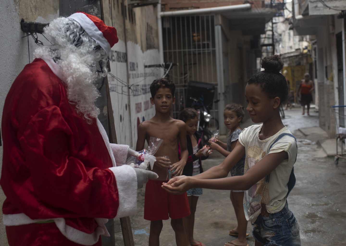 Foto Fabio Teixeira/NurPhoto Papai Noel higieniza as mãos das crianças com álcool para se protegerem do Coronavírus e distribui doces na favela da Mare, no Rio de Janeiro. Foto Fabio Teixeira/NurPhoto