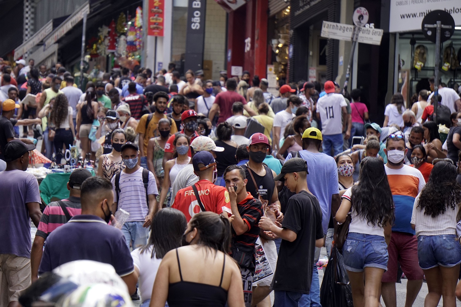 Com máscara e sem máscara, pessoas se aglomeram para fazer as compras de Natal na tradicional rua 25 de março, em São Paulo. Foto Cris Paga/NurPhoto