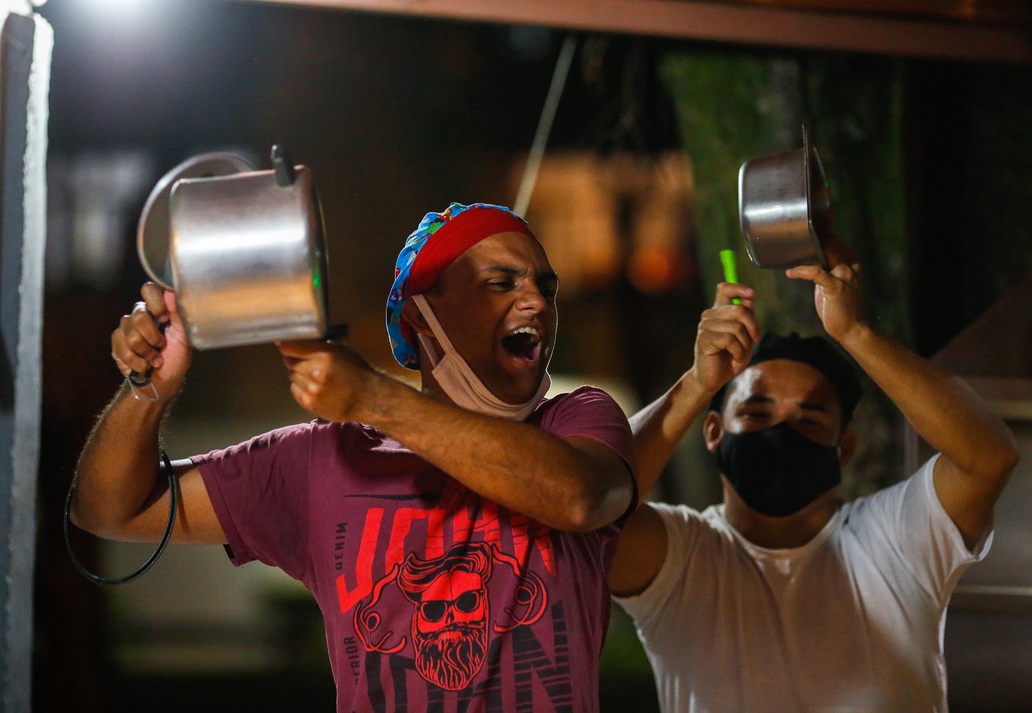 Foto Sérgio Lima/AFP Homens batem panelas em protesto contra o presidente Jair Bolsonaro ao proferir um discurso na TV, em Brasília, no dia 15 de janeiro. Foto Sérgio Lima/AFP