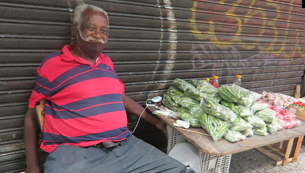 Foto Pedro Madeira Seu Jaime sorri para a foto, ao lado dos produtos que vende diariamente na Praça Tiradentes. Foto Pedro Madeira