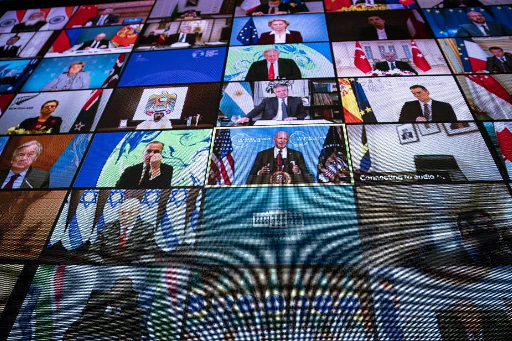 Líderes mundiais - entre eles, Bolsonaro (embaixo) - no telão durante o discurso do presidente dos EUA: novas metas de redução das emissões (Foto: Pool / Getty Images / AFP)