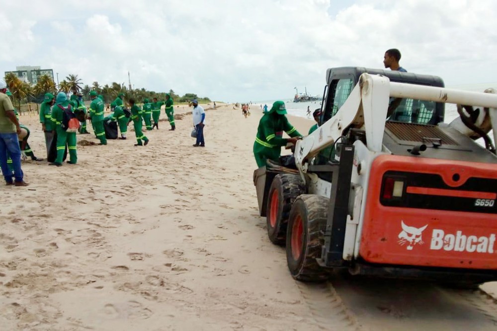 Funcionários da empresa de limpeza recolhem lixo na praia do Bessa, em João Pessoa: 40 toneladas retiradas na Paraíba (Foto: Divulgação/ PMJP)